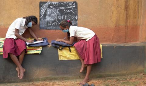 Students studying outside of the mud house to continue their class while covid-19