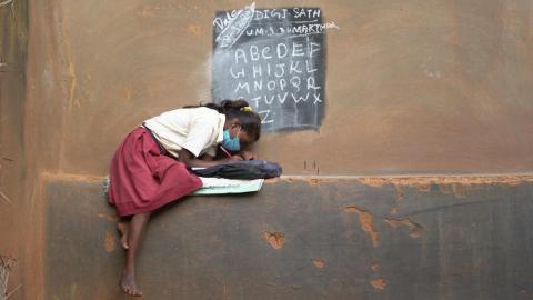 Girl reading in front of blackboard during the lockdown