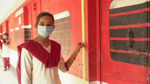 Girl student standing at the school campus wearing a mask