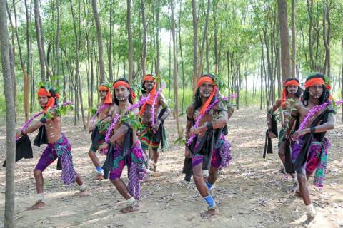 Tribal people performing shikari dance between the jungle