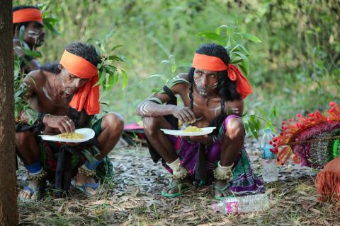 A group of tribal male artist having food in jungle