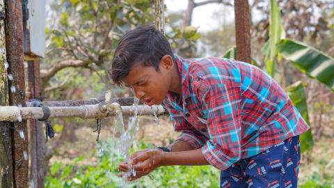 Village boy washing his face