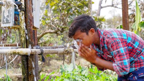 Village boy washing his face